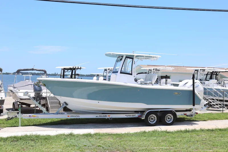Slide: The Image of 2027 Sea Hunt Gamefish 25 boat on trailer by waterfront, clear sky background. - 29