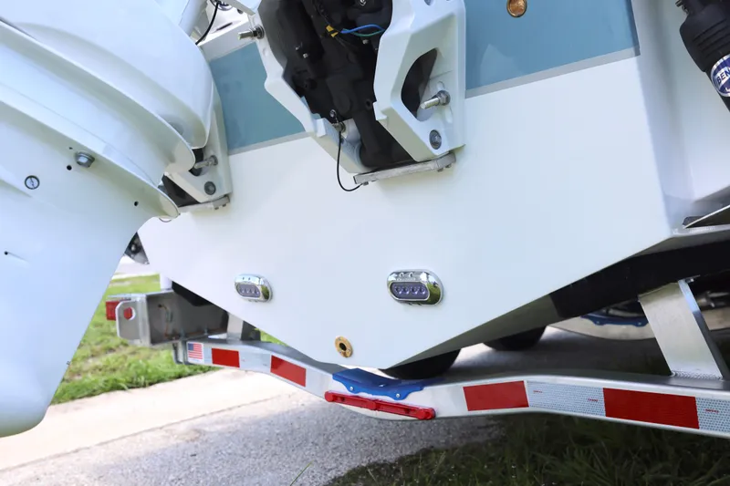 Slide: The Image of Rear view of a 2027 Sea Hunt Gamefish 25 boat on a trailer, showcasing its motor and hull. - 28