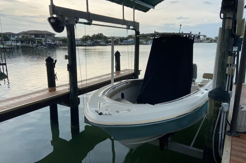 Slide: The Image of 2016 Pioneer 197 Sportfish boat docked on a lift by a serene waterfront. - 8