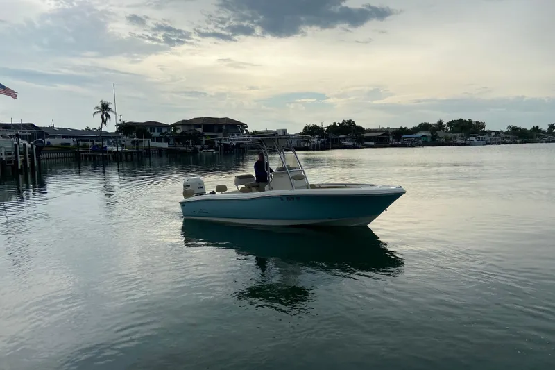Slide: The Image of 2016 Pioneer 197 Sportfish boat on calm water at sunset, near a residential dock. - 5