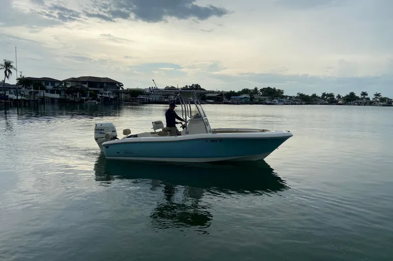Slide: The Image of 2016 Pioneer 197 Sportfish boat on calm water at sunset, near waterfront homes. - 6