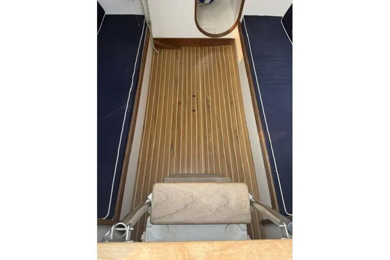 Slide: The Image of 2001 J Boats J/105 interior with wooden flooring and blue cushioned seating. - 13