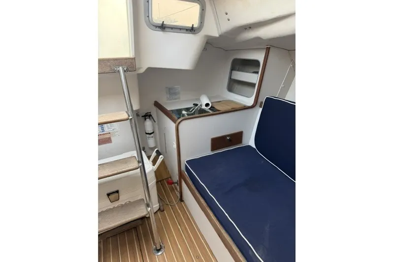 Slide: The Image of Interior of 2001 J Boats J/105 sailboat with blue seating and wooden flooring. - 17