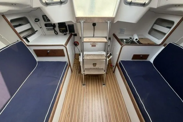Slide: The Image of Interior of a 2001 J Boats J/105 sailboat with blue seating and wooden flooring. - 14