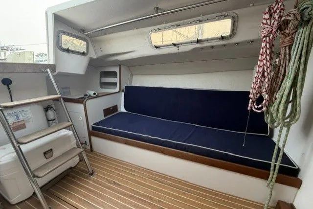 Slide: The Image of Interior of 2001 J Boats J/105 sailboat with blue seating and wooden flooring. - 15