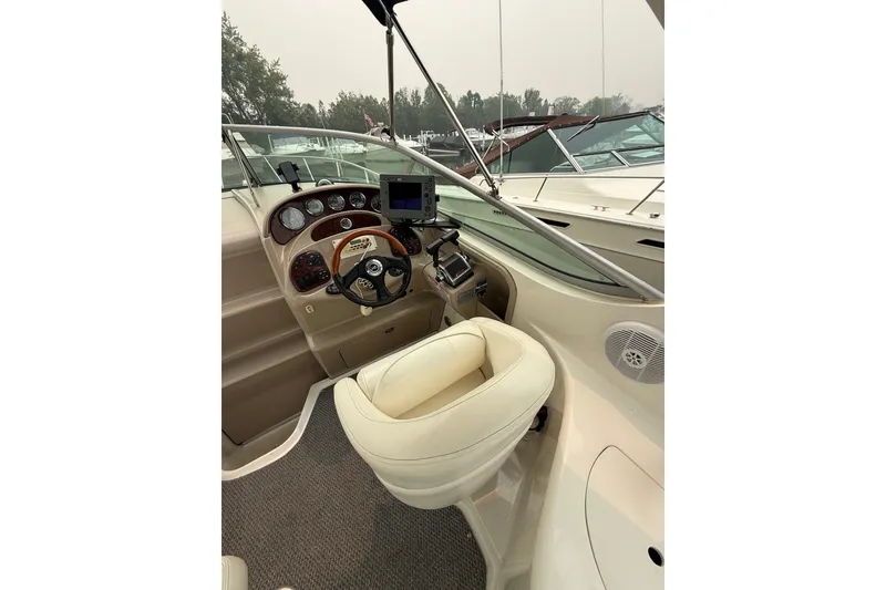 Slide: The Image of 2004 Sea Ray Sundancer 280 helm with steering wheel, gauges, and navigation equipment. - 10