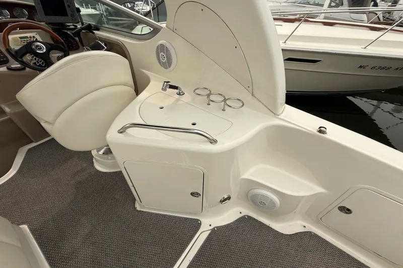 Slide: The Image of 2004 Sea Ray Sundancer 280 cockpit with helm, seating, and sink area. - 6