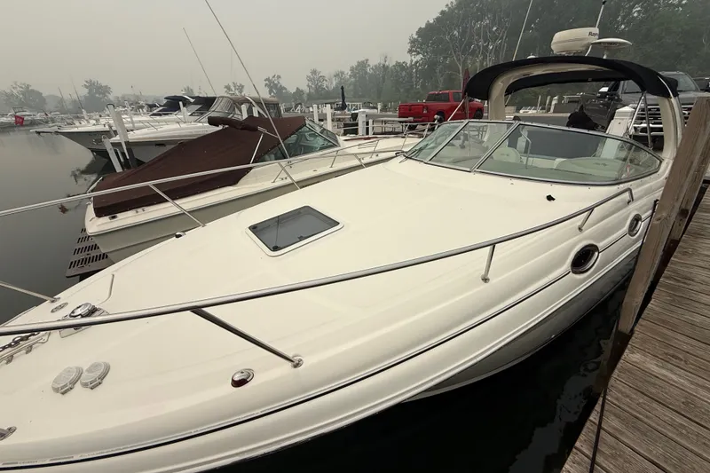 Slide: The Image of 2004 Sea Ray Sundancer 280 docked at marina, showcasing sleek design and spacious deck. - 1