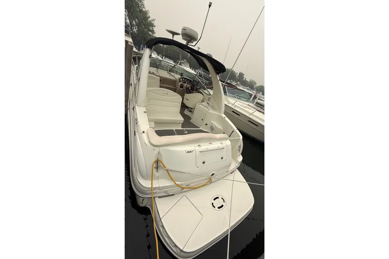 Slide: The Image of 2004 Sea Ray Sundancer 280 boat docked, featuring spacious cockpit and sleek design. - 4