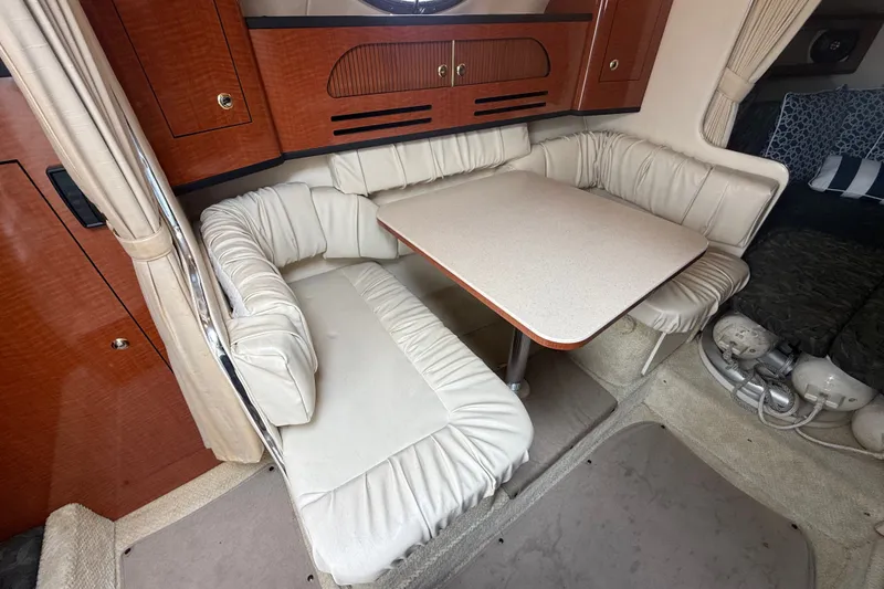 Slide: The Image of 2004 Sea Ray Sundancer 280 interior with cozy dining area and plush seating. - 16