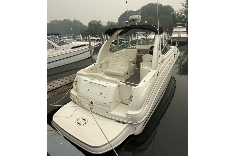 Slide: The Image of 2004 Sea Ray Sundancer 280 docked at marina, showcasing sleek design and spacious interior. - 3