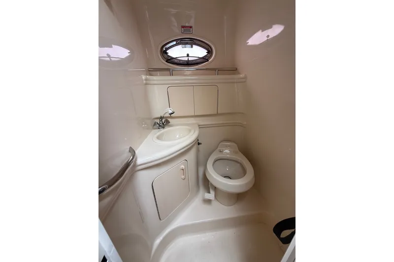 Slide: The Image of 2004 Sea Ray Sundancer 280 boat bathroom with sink, toilet, and porthole window. - 18