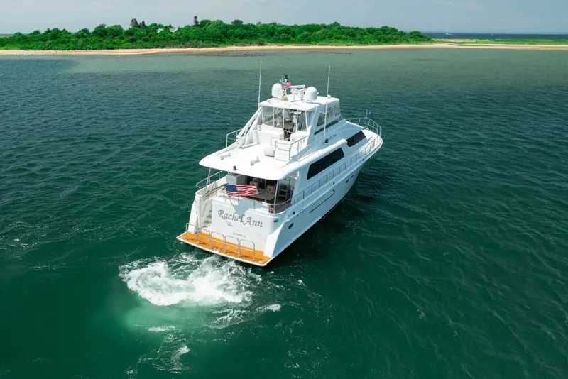 Slide: The Image of 2004 Cheoy Lee Flybridge yacht cruising near a lush green island. - 6