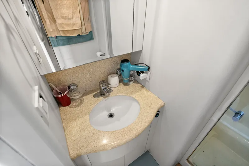 Slide: The Image of 2004 Cheoy Lee Flybridge bathroom with sink, mirror, and toiletries. - 41