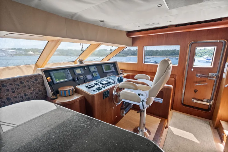 Slide: The Image of Luxurious 2004 Cheoy Lee Flybridge yacht helm with modern navigation equipment and plush seating. - 26