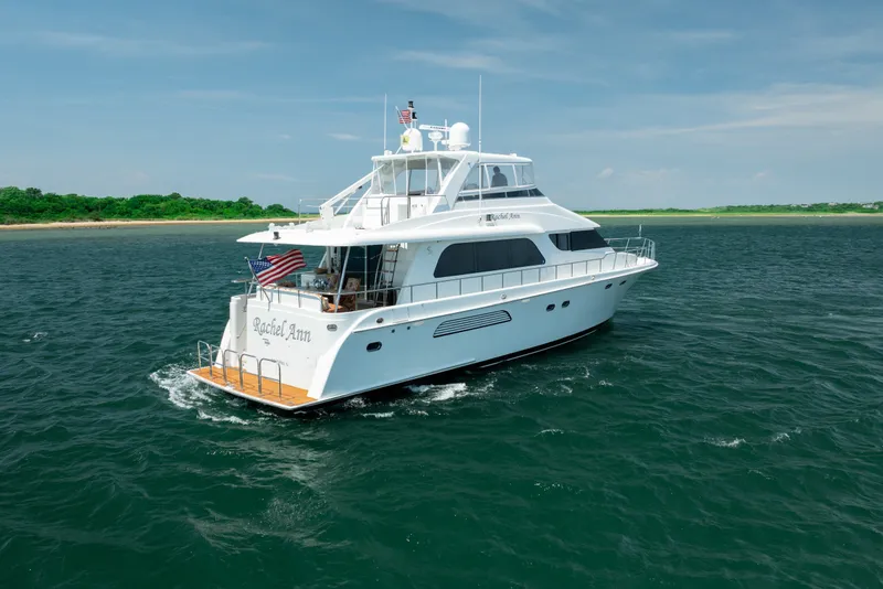 Slide: The Image of 2004 Cheoy Lee Flybridge yacht cruising on open water near a lush coastline. - 4