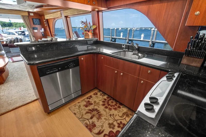 Slide: The Image of Luxurious 2004 Cheoy Lee Flybridge yacht kitchen with ocean view, featuring sleek countertops and modern appliances. - 23