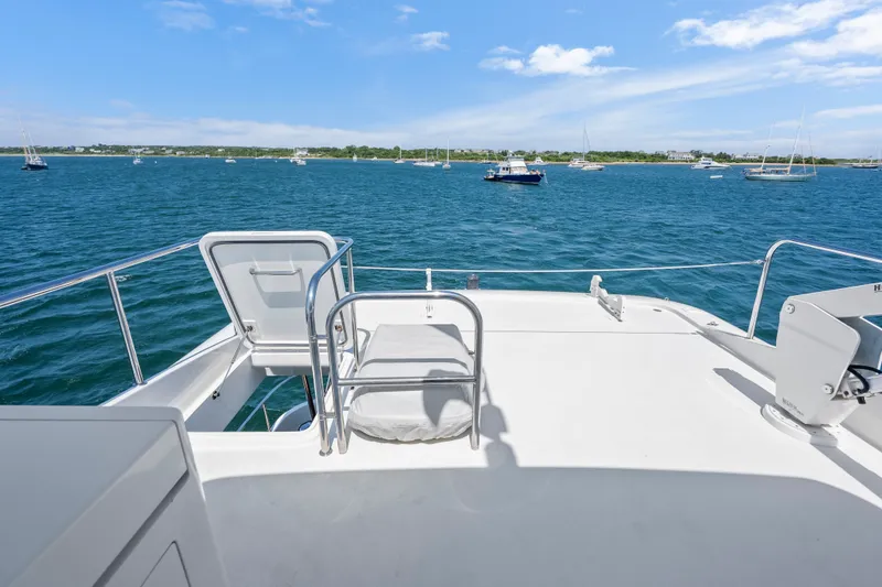 Slide: The Image of 2004 Cheoy Lee Flybridge yacht deck overlooking serene blue waters and anchored boats. - 12