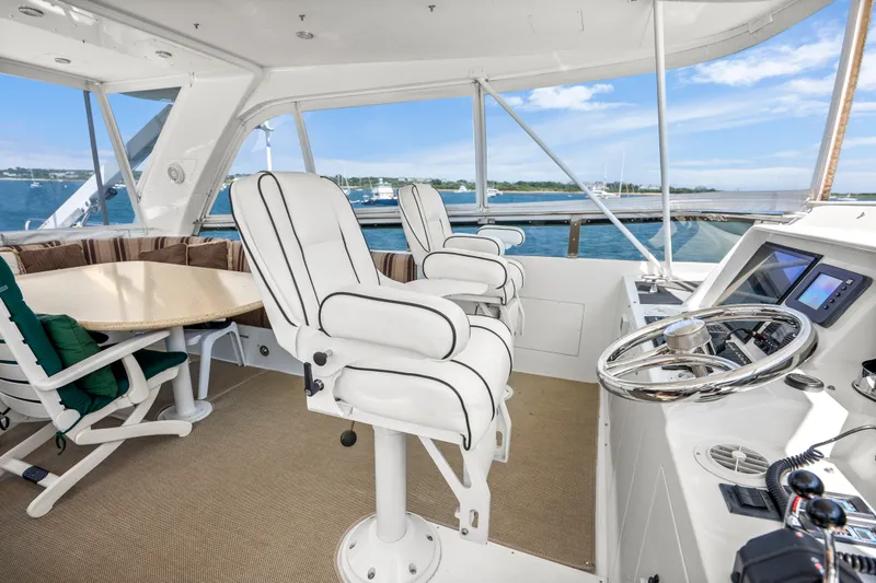 Slide: The Image of 2004 Cheoy Lee Flybridge yacht interior with helm, seating, and ocean view. - 16