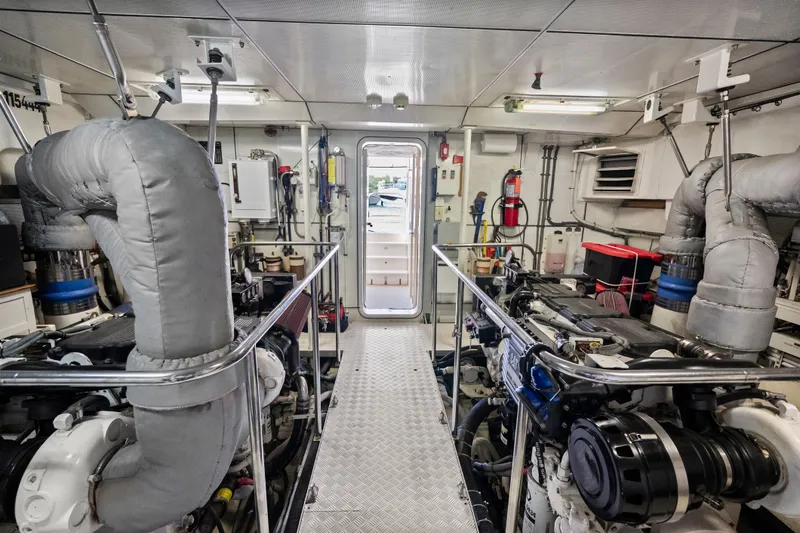 Slide: The Image of Engine room of 2004 Cheoy Lee Flybridge yacht, featuring dual engines and modern equipment. - 43