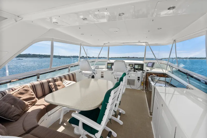 Slide: The Image of Luxurious 2004 Cheoy Lee Flybridge yacht interior with seating, table, and ocean view. - 15