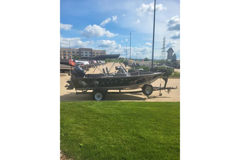 Slide: The Image of 2014 G3 Angler V172 FS boat on trailer, parked outdoors under a clear blue sky. - 2