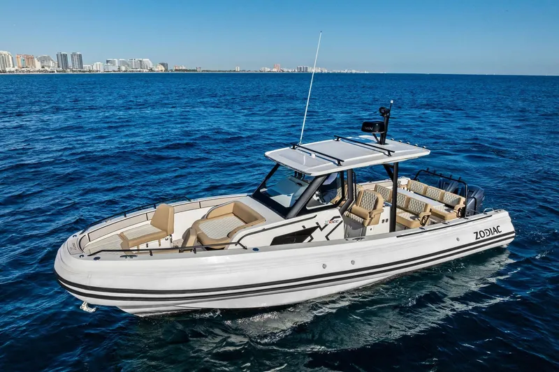Slide: The Image of 2025 Zodiac X10CC boat cruising on open blue ocean near city skyline. - 10
