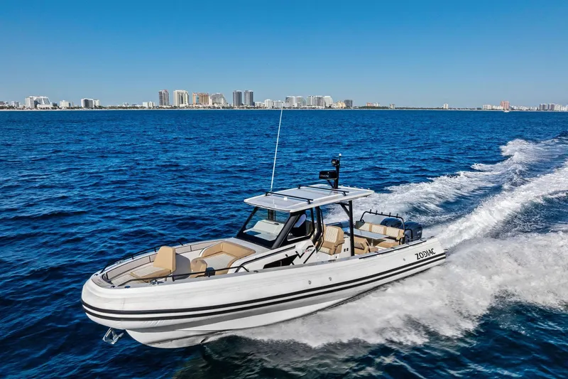 Slide: The Image of 2025 Zodiac X10CC boat cruising on blue ocean near city skyline. - 5