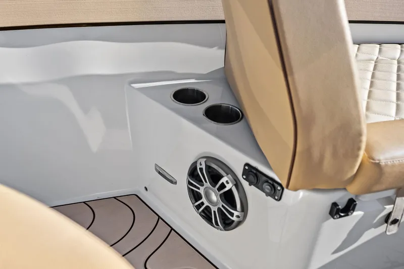 Slide: The Image of 2025 Zodiac X10CC boat interior with beige seating, cup holders, and speaker system. - 45