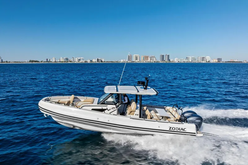 The Image of 2025 Zodiac X10CC boat cruising on blue ocean with city skyline in background. - 4