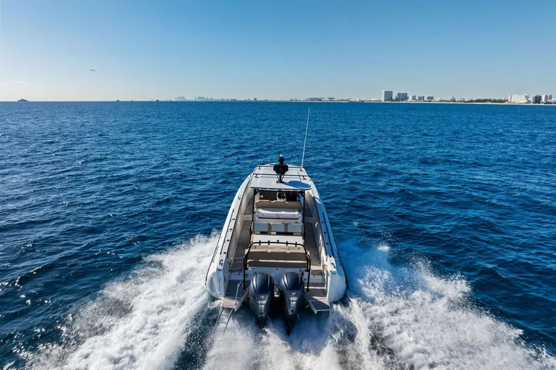 Slide: The Image of 2025 Zodiac X10CC boat cruising on open ocean with city skyline in background. - 2