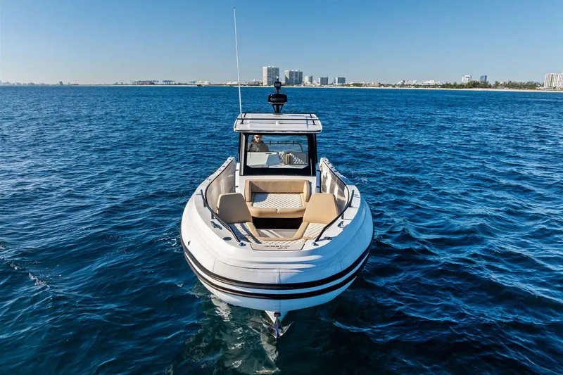 Slide: The Image of 2025 Zodiac X10CC boat cruising on open blue water near city skyline. - 11