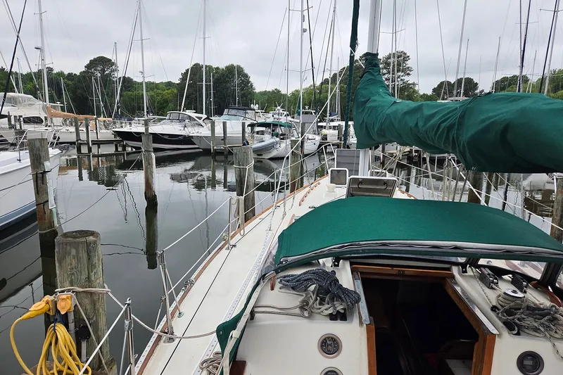 Slide: The Image of 1983 Sabre 38 sailboat docked in a marina, surrounded by other boats. - 9