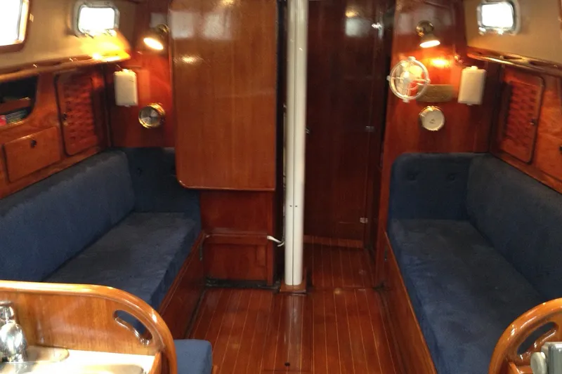 Slide: The Image of Interior of a 1983 Sabre 38 sailboat with wooden finish and blue seating. - 16