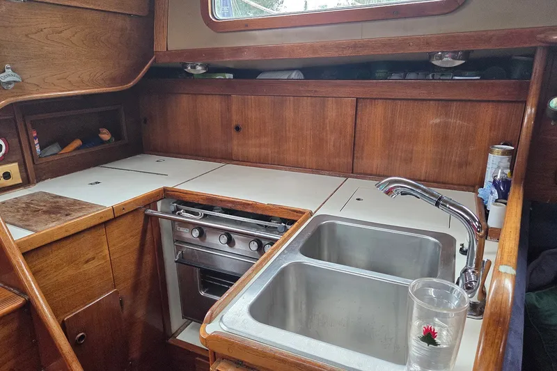 Slide: The Image of 1983 Sabre 38 yacht kitchen with wooden cabinetry, stainless steel sink, and stove. - 20