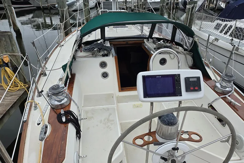 Slide: The Image of 1983 Sabre 38 sailboat cockpit with steering wheel and navigation equipment at marina. - 3