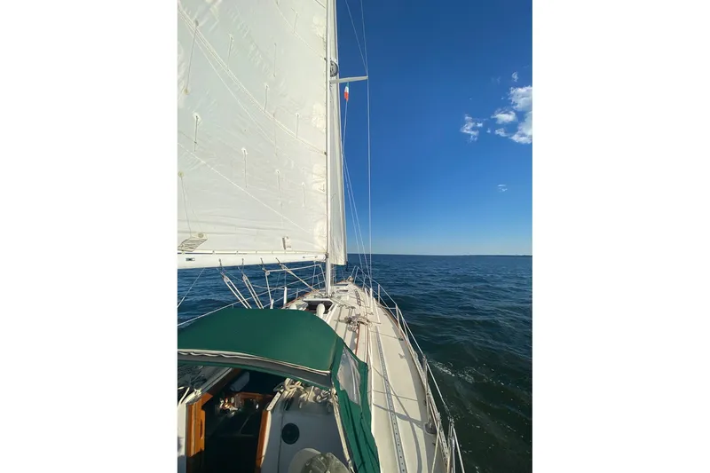 Slide: The Image of 1983 Sabre 38 sailboat cruising on open sea under clear blue sky. - 13