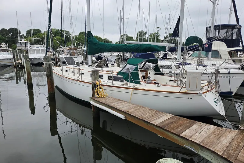 The Image of 1983 Sabre 38 sailboat docked at a marina, surrounded by other boats. - 1