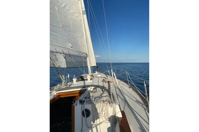 Slide: The Image of 1983 Sabre 38 sailboat on open water under clear blue sky. - 14