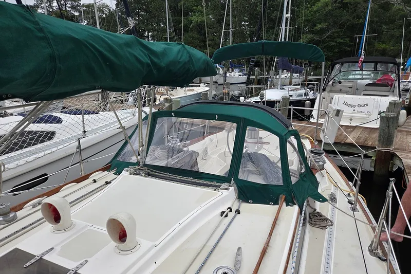 Slide: The Image of 1983 Sabre 38 sailboat docked in a marina with green canvas covers. - 6