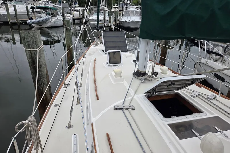 Slide: The Image of 1983 Sabre 38 sailboat deck view at marina, featuring open hatch and rigging. - 8