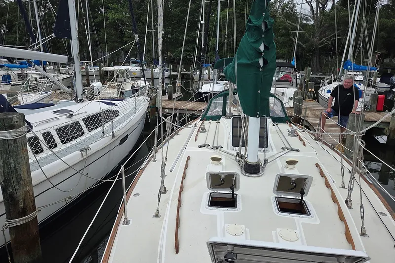 Slide: The Image of 1983 Sabre 38 sailboat docked at marina, surrounded by other boats. - 5