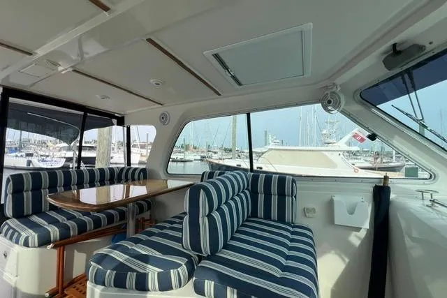 Slide: The Image of Interior of a 2008 Back Cove 33 boat with striped seating and marina view. - 14