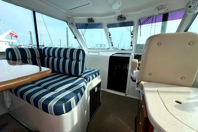 Slide: The Image of Interior of 2008 Back Cove 33 boat with striped seating and helm station. - 13