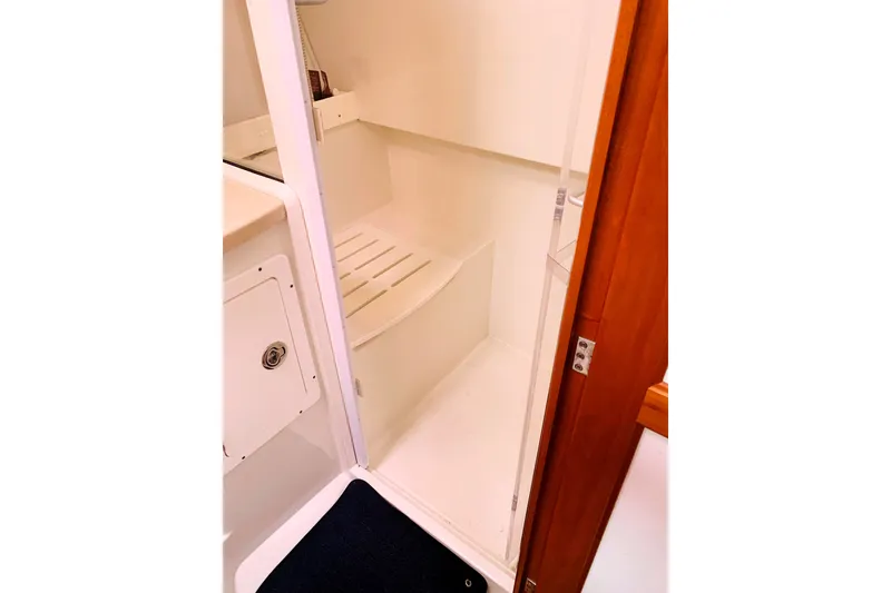 Slide: The Image of 2008 Back Cove 33 yacht interior shower area with wooden door and white fixtures. - 16