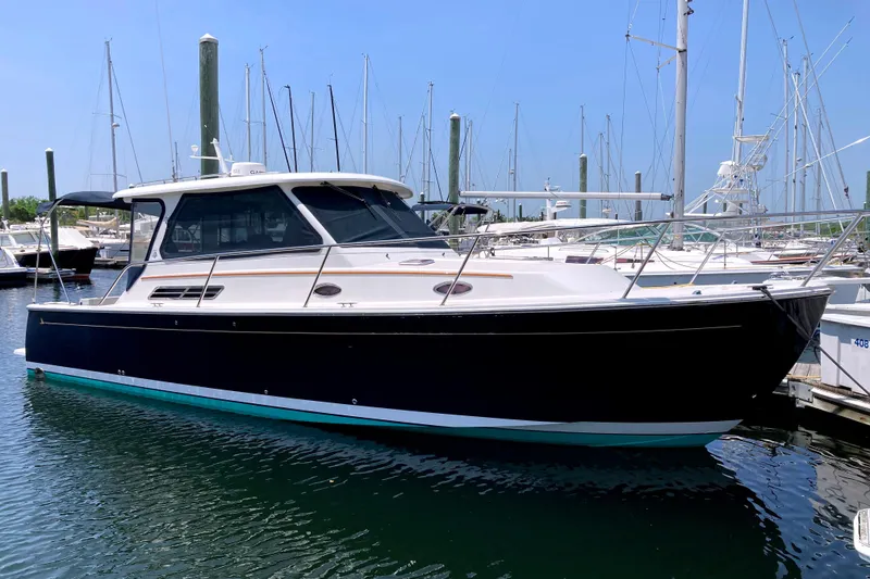The Image of 2008 Back Cove 33 boat docked in marina, surrounded by sailboats under clear blue sky. - 0