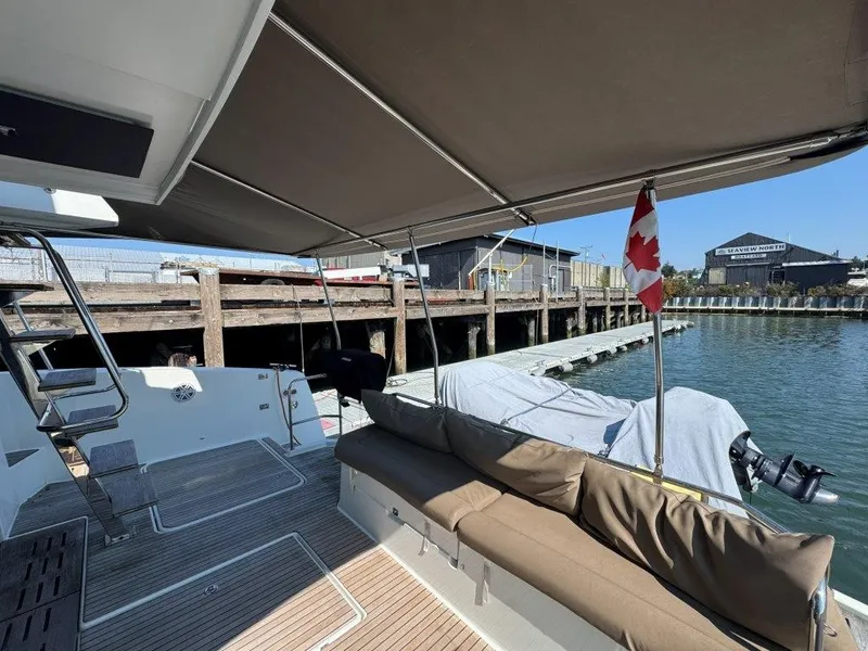 Slide: The Image of A 2016 Fountaine Pajot Motor Yacht 37 docked. It features a covered seating area with a Canadian flag. - 5