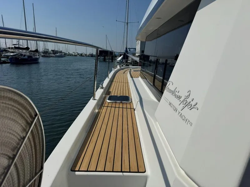 Slide: The Image of The 2016 Fountaine Pajot Motor Yacht 37 is docked, featuring a sleek teak deck. - 38