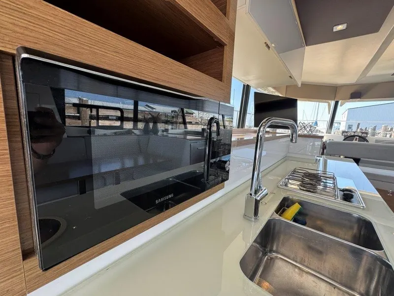 Slide: The Image of The galley of a 2016 Fountaine Pajot Motor Yacht 37 with sink, stove, and microwave. - 12