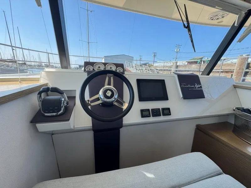 Slide: The Image of The image shows the helm of a 2016 Fountaine Pajot Motor Yacht 37 with a modern steering wheel and instruments. - 13